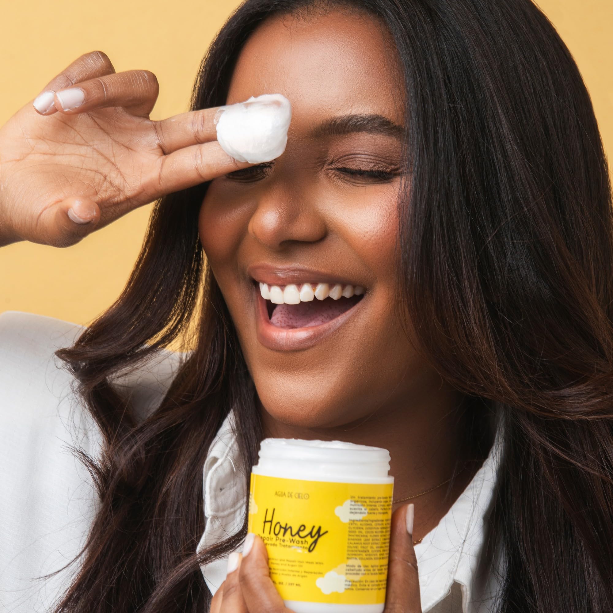 Hands apply Agua de Cielo Honey Repair before washing to help prevent breakage