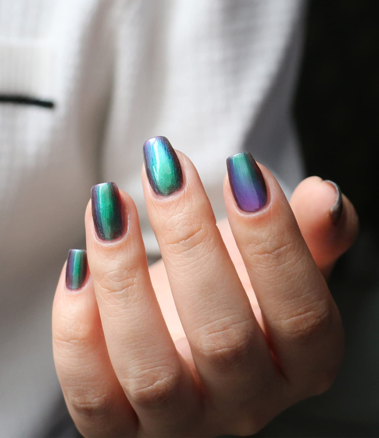 AILALUO Chrome nail polish bottle and nails sparkling in daylight.