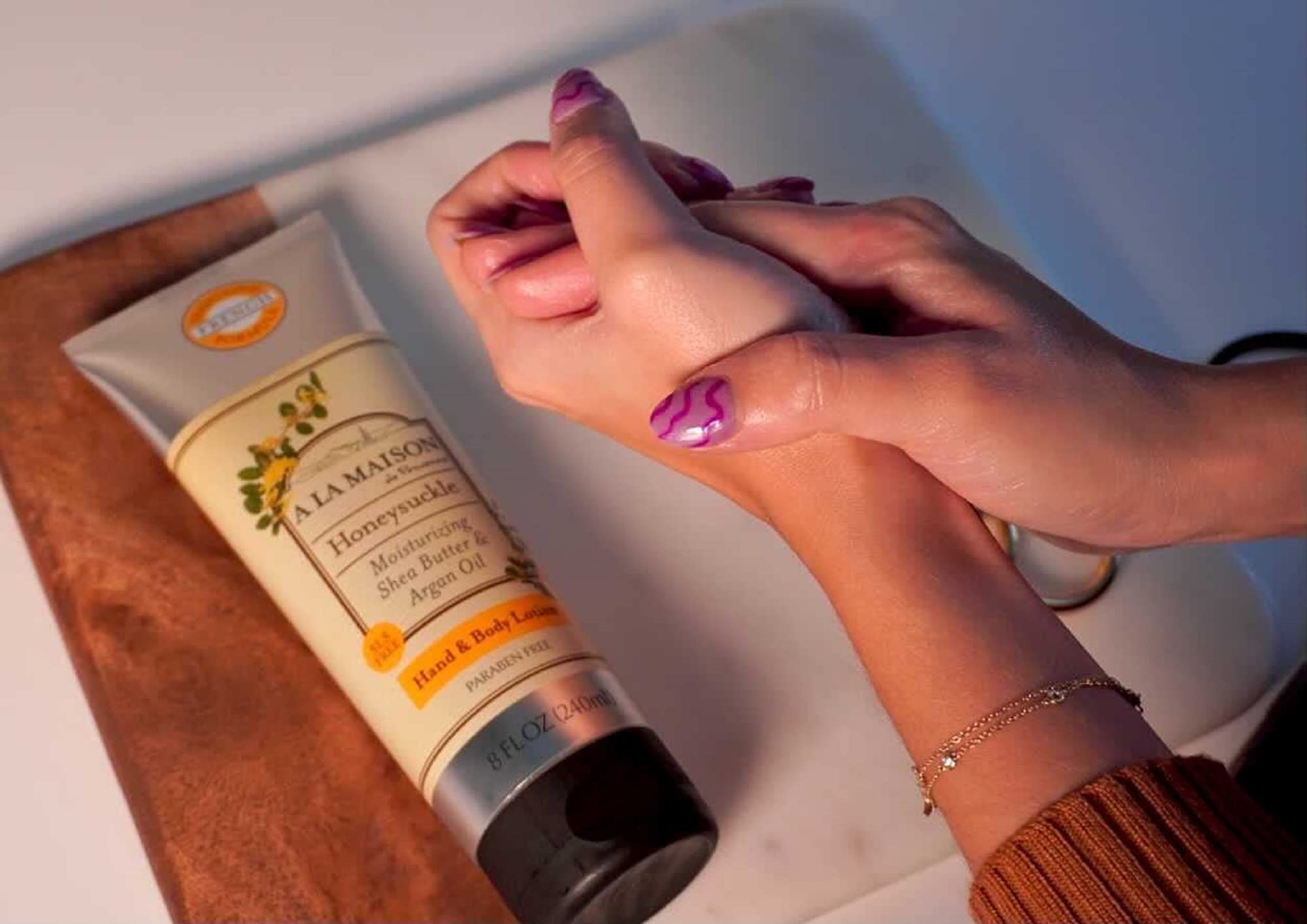 A LA MAISON honeysuckle lotion pump in use for quick hydration.