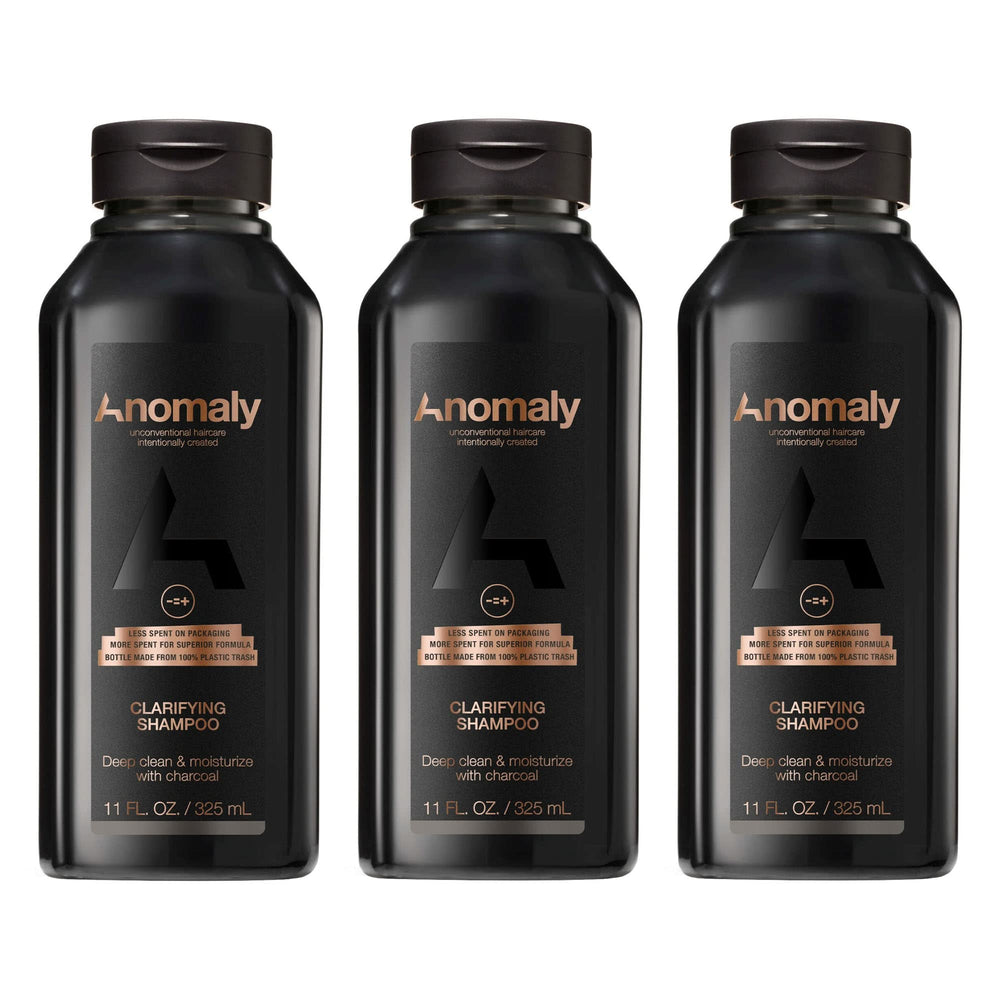 Anomaly clarifying shampoo bottle pour showing charcoal cleanse for buildup control