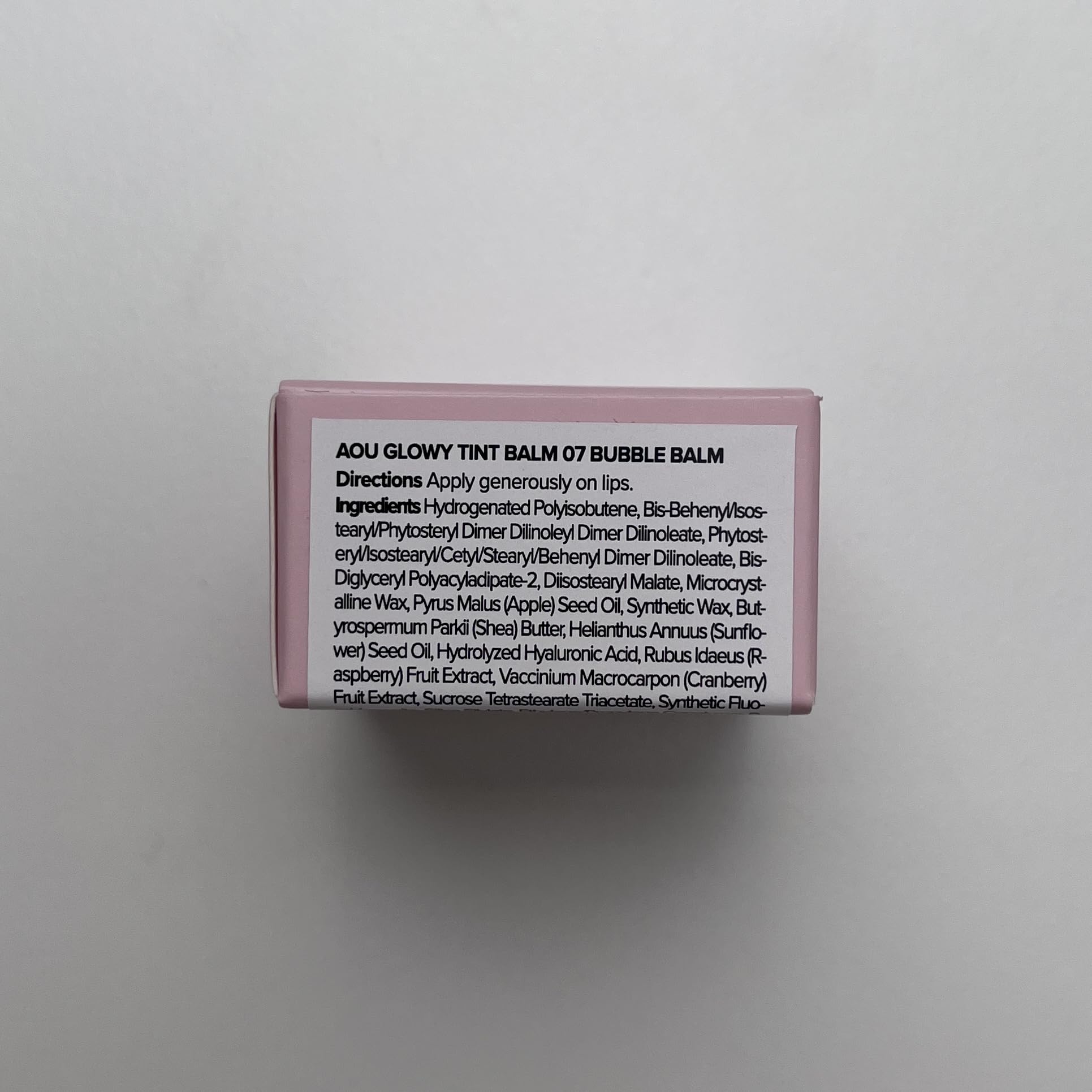 AOU Glowy Tint Balm tube held for travel-friendly use