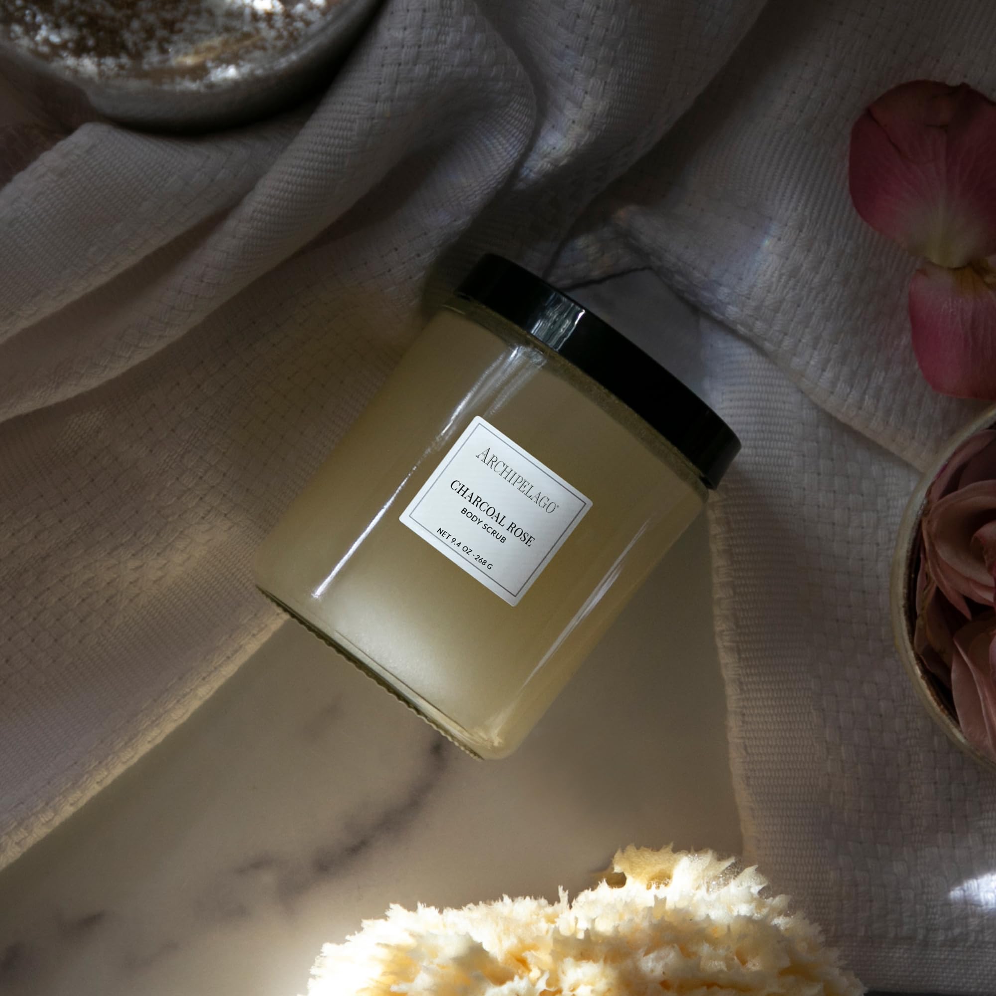 Jar closeup of Archipelago Botanicals Charcoal Rose Scrub highlighting natural ingredients for moisturized skin