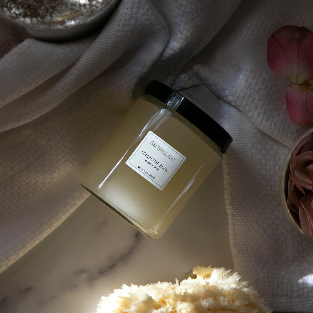 Jar closeup of Archipelago Botanicals Charcoal Rose Scrub highlighting natural ingredients for moisturized skin