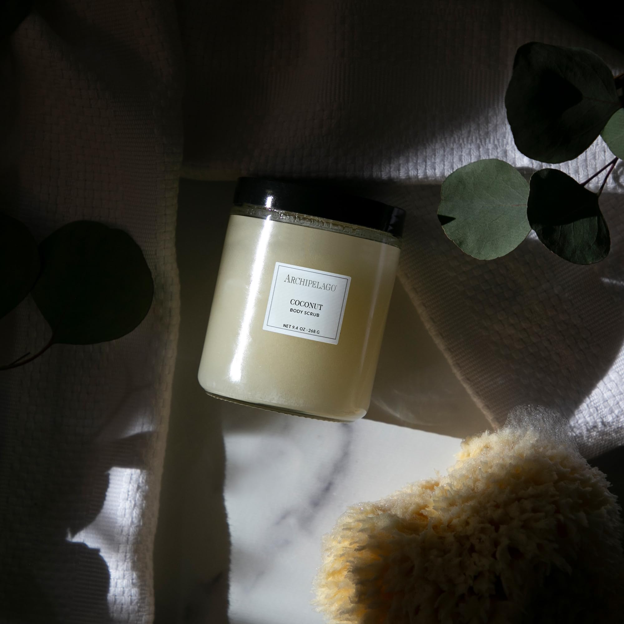 Archipelago Botanicals Coconut Body Scrub scoop application shows gentle exfoliation