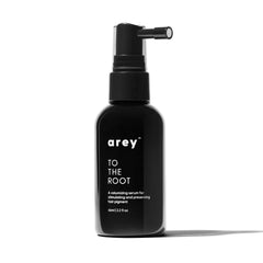 Arey To The Root Serum bottle pump resting on a clean surface for easy application