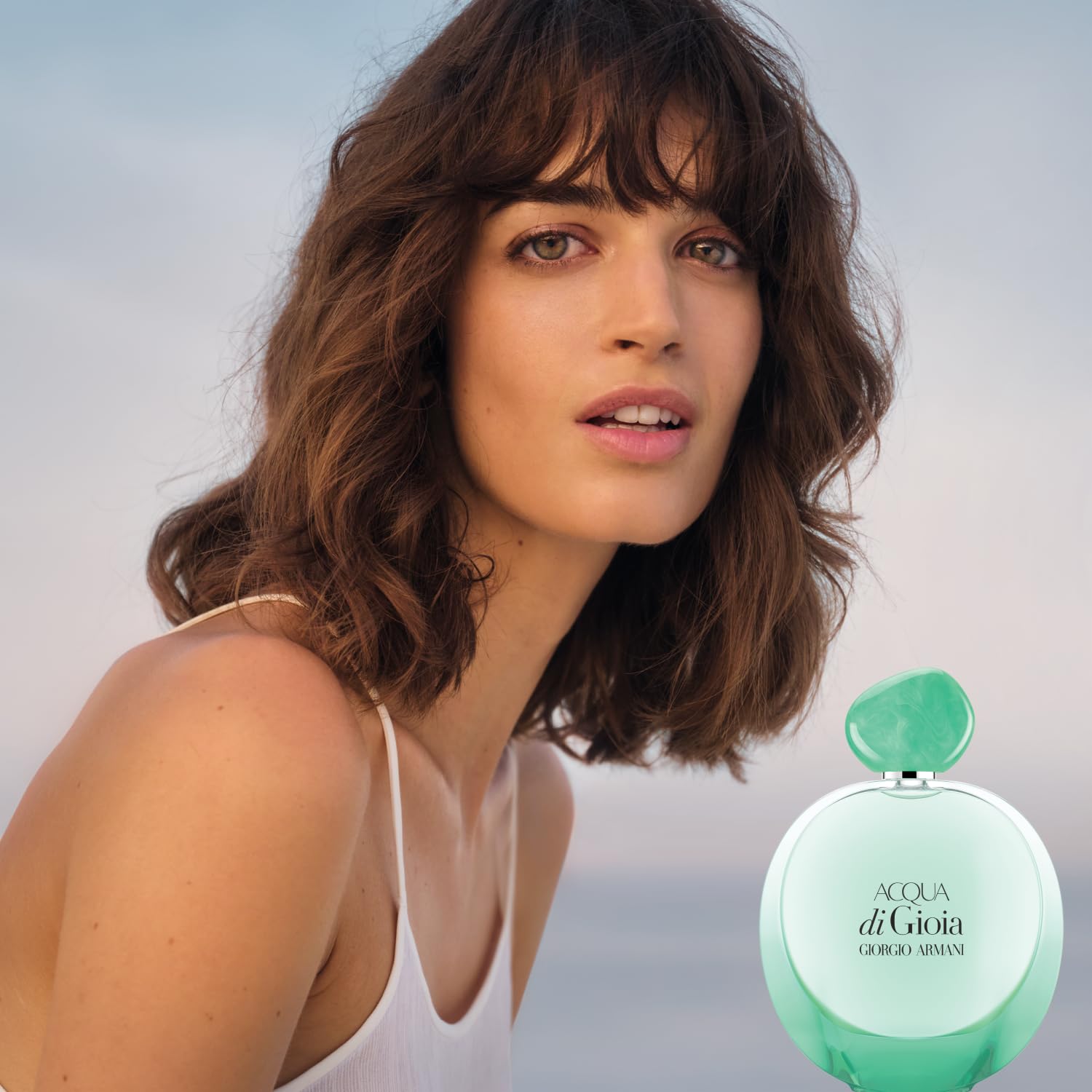 Armani Beauty Acqua di Gioia Intense bottle glow complements summer outfits.
