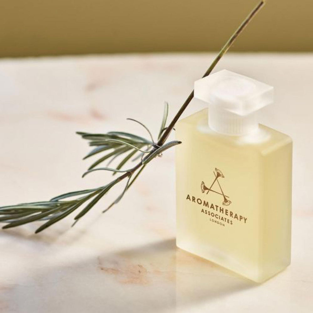 Hands massaging De-Stress Mind oil onto back for relaxation and centering