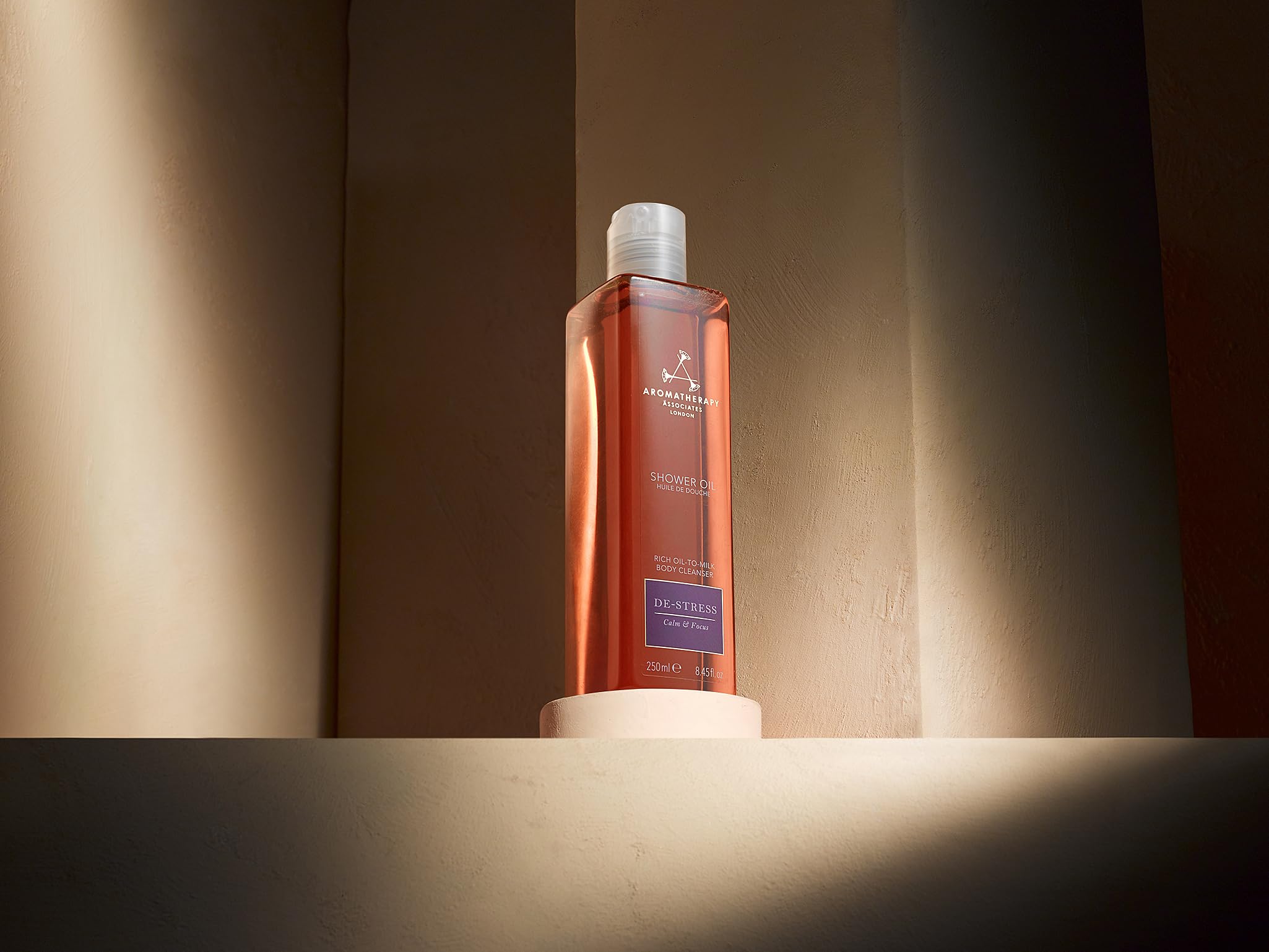Hands massaging De-Stress Mind oil into damp skin to hydrate.