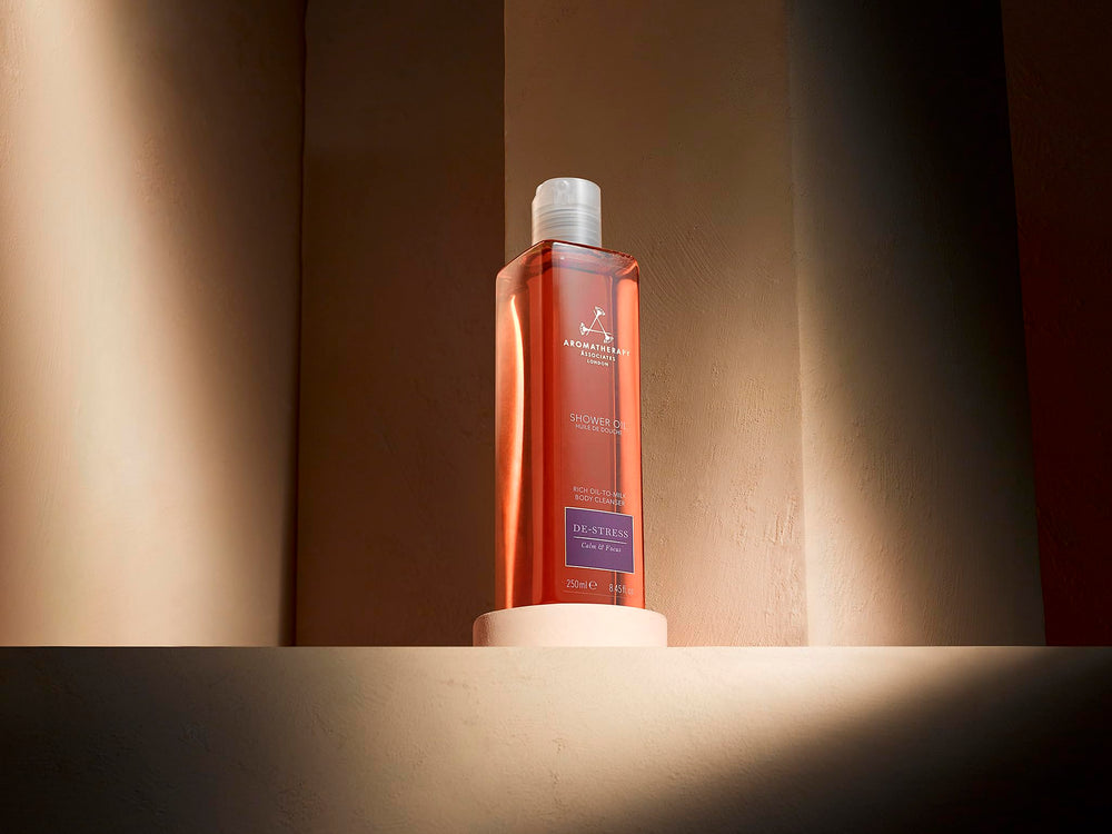 Hands massaging De-Stress Mind oil into damp skin to hydrate.