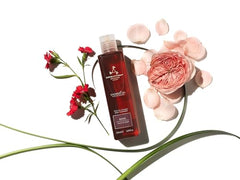 Aromatherapy Associates Rose Shower Oil being poured into a cupped hand for cleansing ritual.