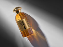 Atralia Tonka Gold bottle on a nighttime vanity with soft lighting.