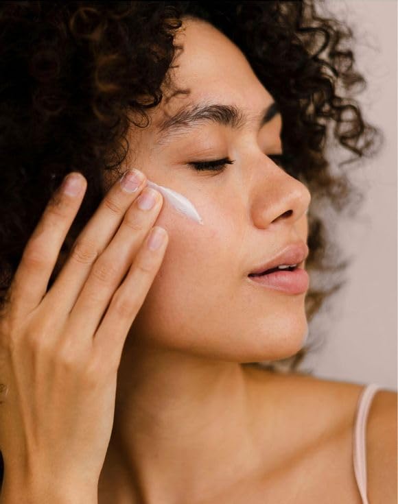 Applying AVON Solutions Nourishing Moisturizing Cream on the face for hydration.