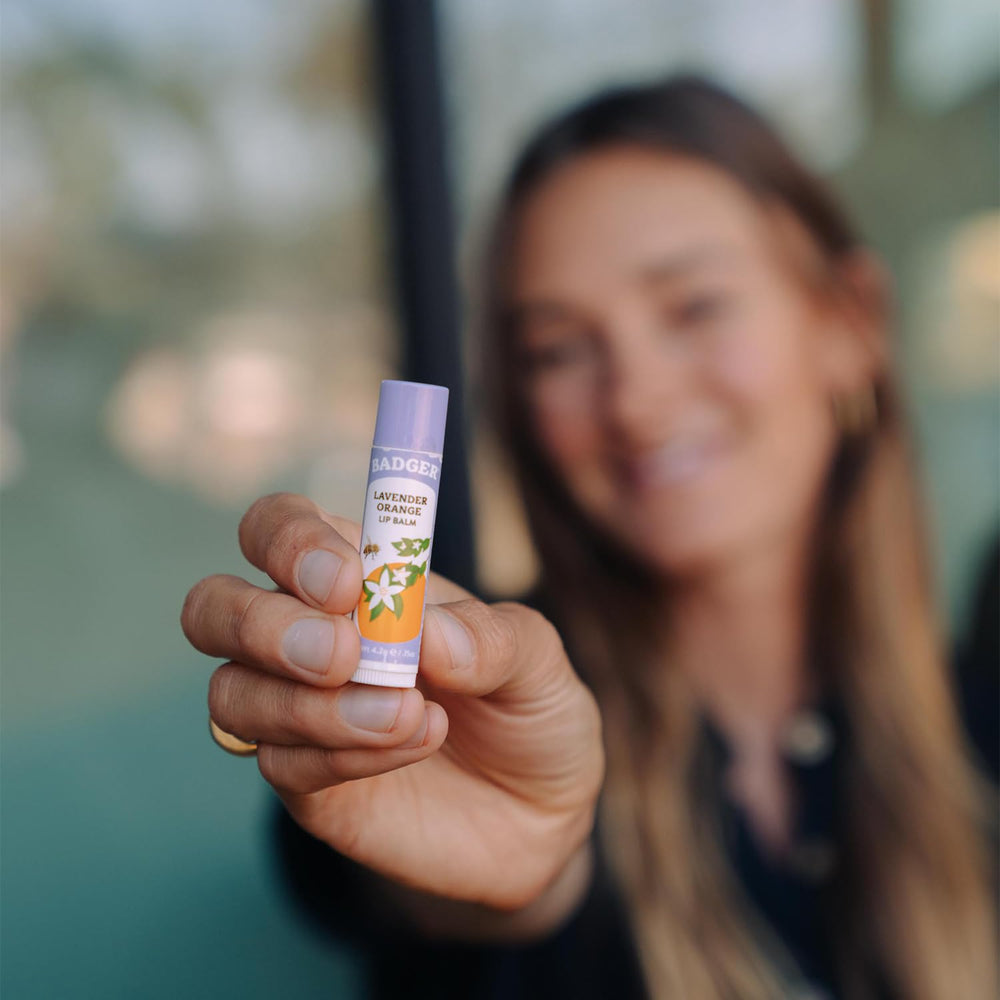 Badger Lavender Orange Lip Balm being applied for smooth lips.
