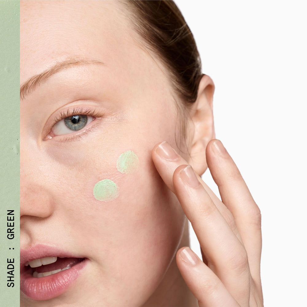 Beauty Pie Superluminous Redness Corrector Green bottle beside moisturizer demonstrates layering.