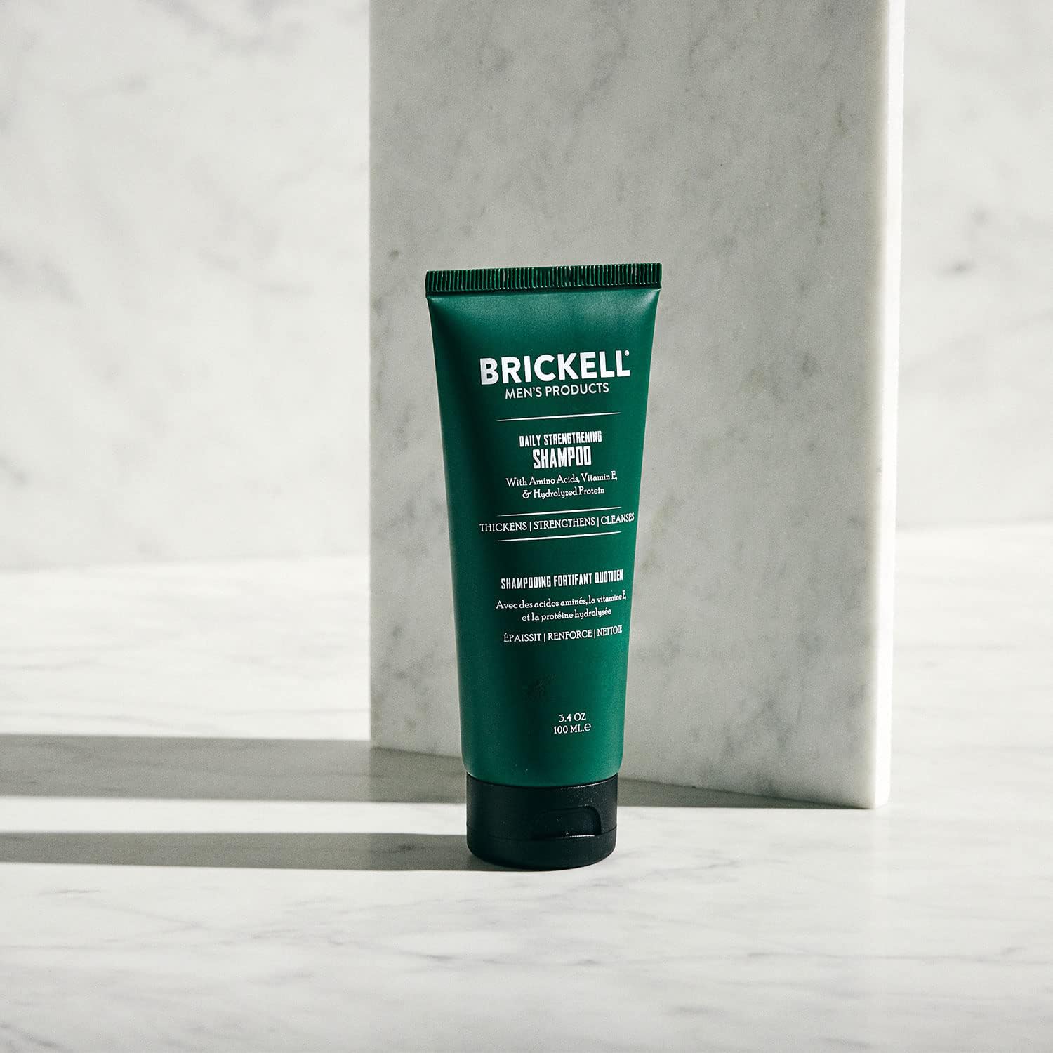 Brickell Daily Strengthening Shampoo lather close-up showing fuller-looking hair and invigorating sensation.