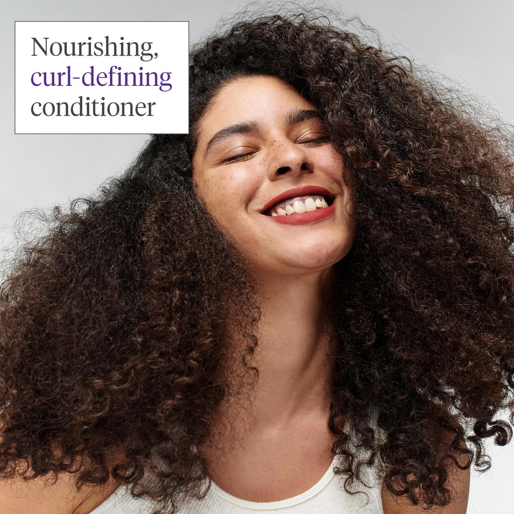Briogeo Curl Charisma hands applying conditioner to hair