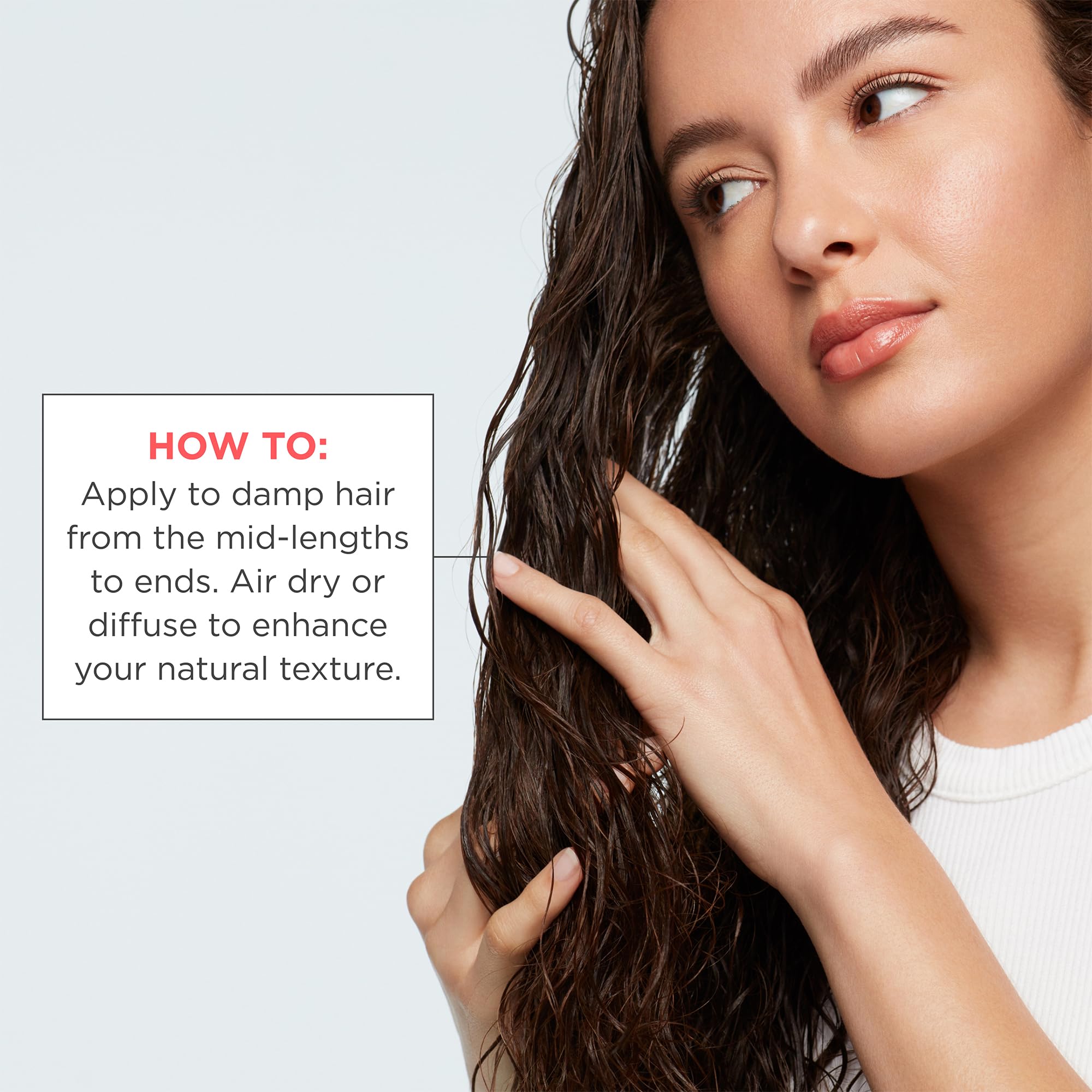 Hands applying product on damp hair emphasizes easy low-maintenance heatless styling