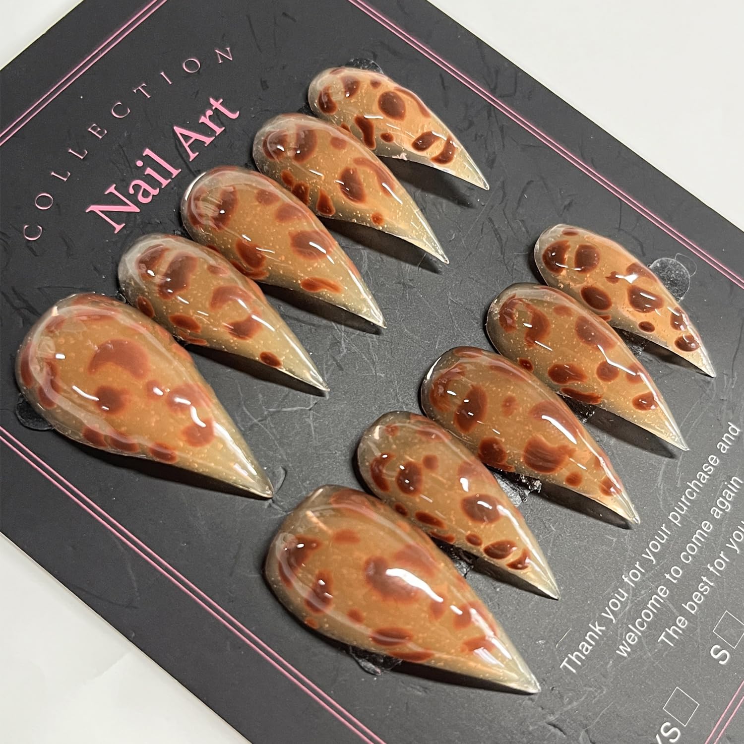 BRKYKGK nails on hand show brown leopard design and stiletto shape.