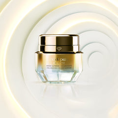 Close-up of Clé de Peau Beauté mini volumizing cream supreme silky texture on skin.