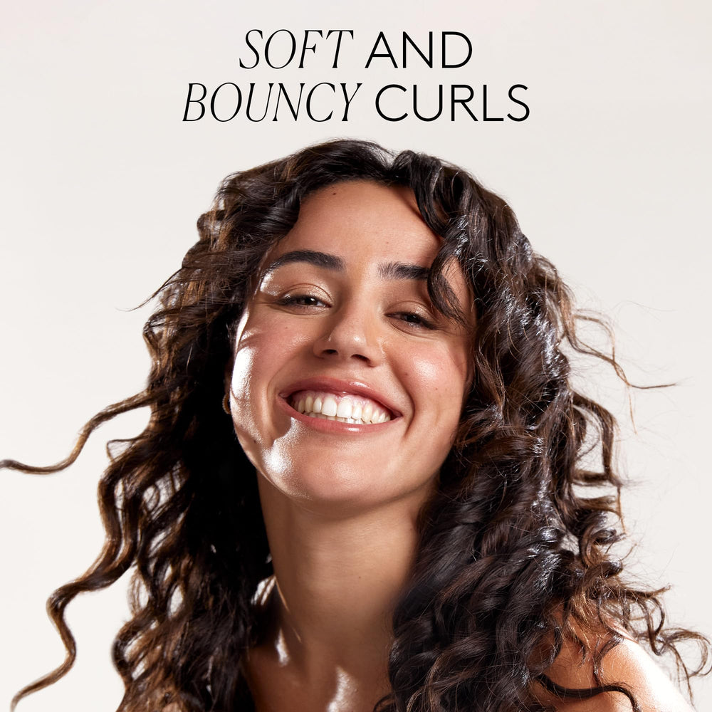 Model curls illustrate defined frizz-free hair with the defining gel