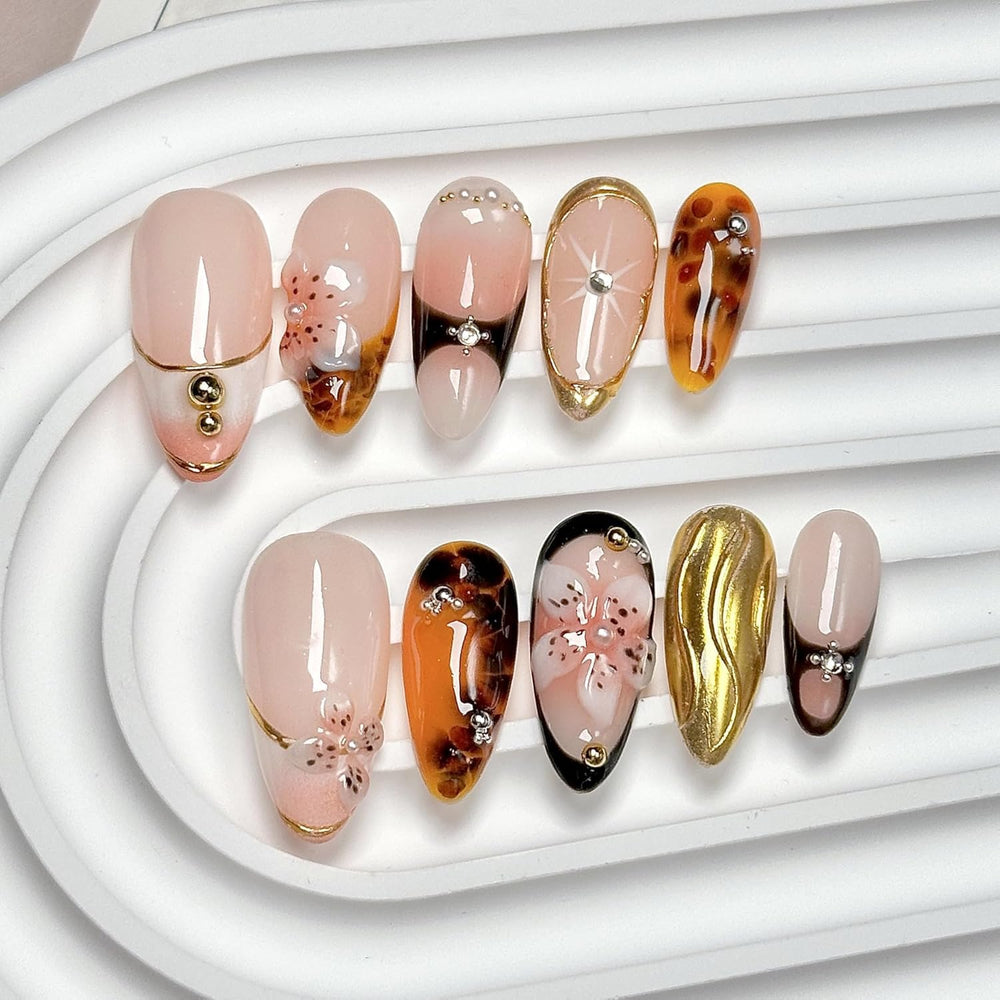 CTTHNBD medium almond nails with brown gold flower design for a stylish everyday look.