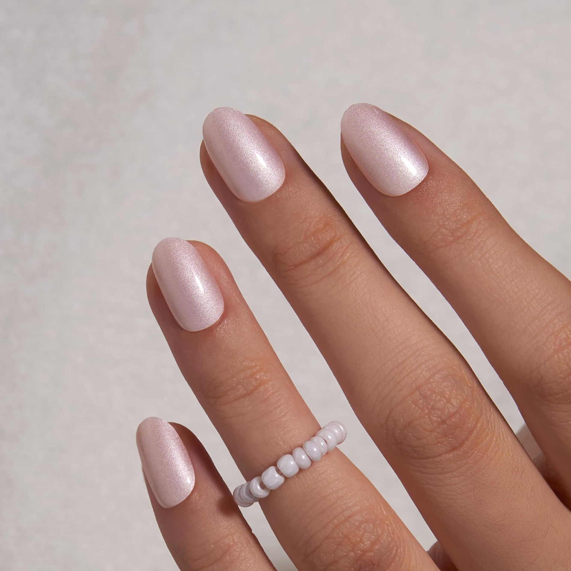 Curvlife short oval Moonlight Pearly Shimmer nails secured with glue for durable wear.