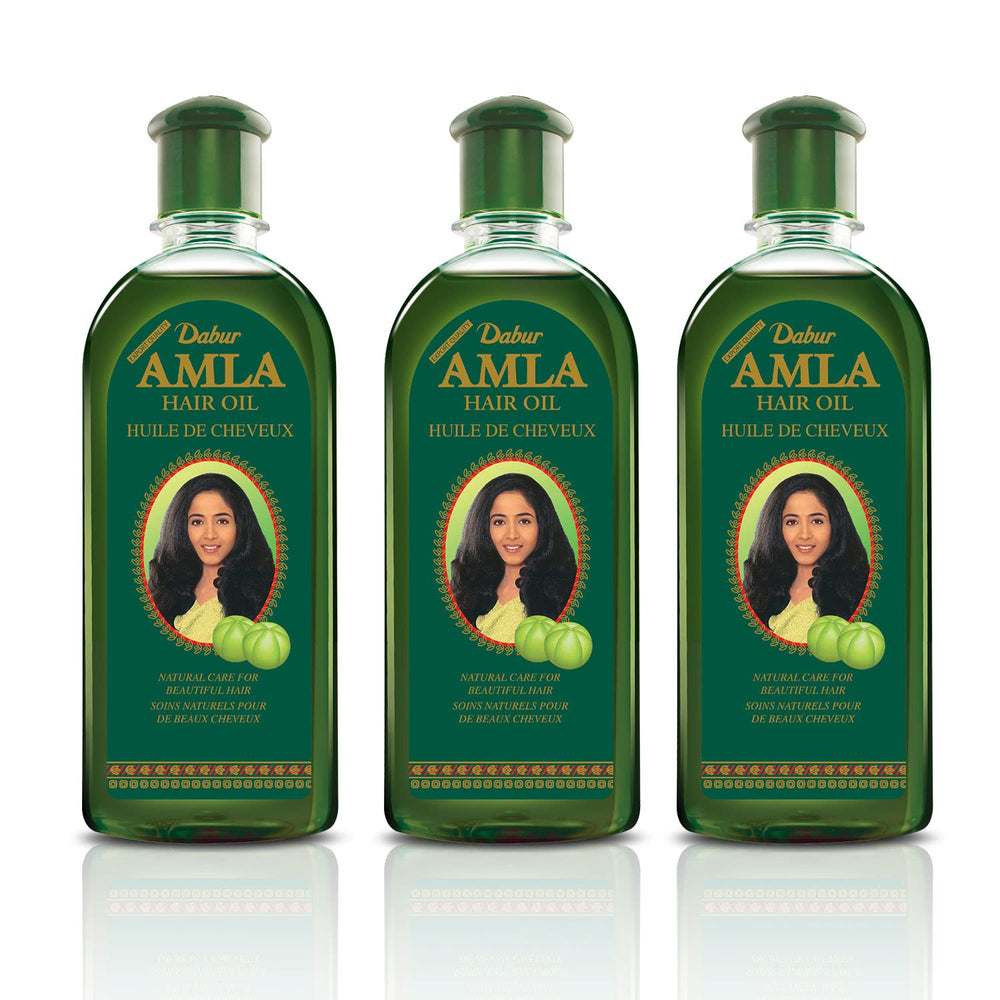 Dabur Amla Hair Oil bottle being poured to suggest easy application and convenience.