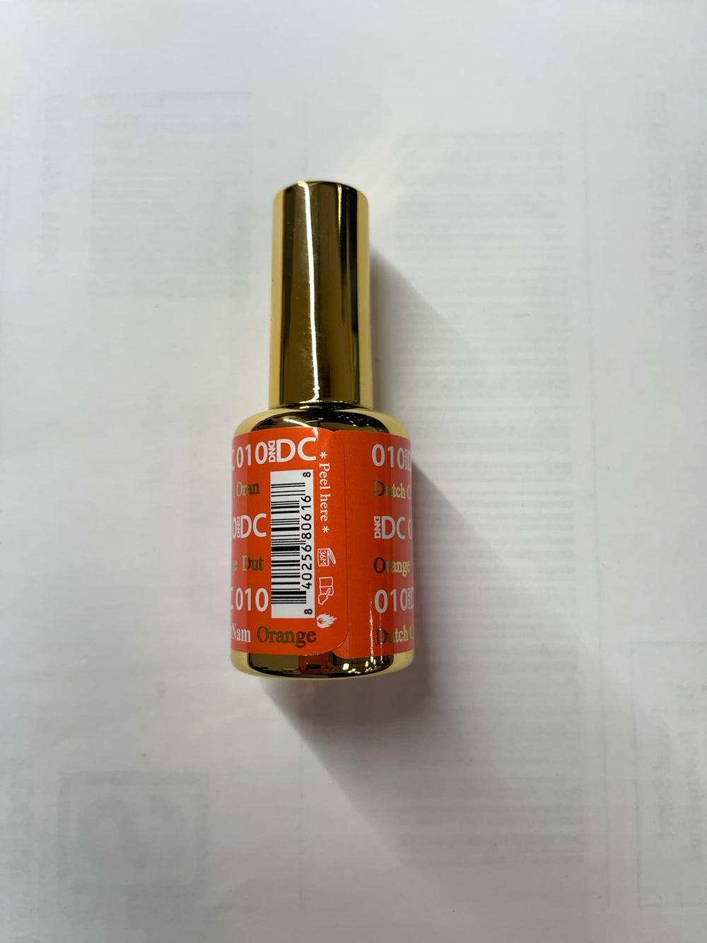 Daisy DND orange lacquer air-dry process displayed on a manicured nail