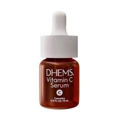 DHEMS Vitamin C Serum bottle pour demonstrates quick absorption for a refreshed, radiant complexion.