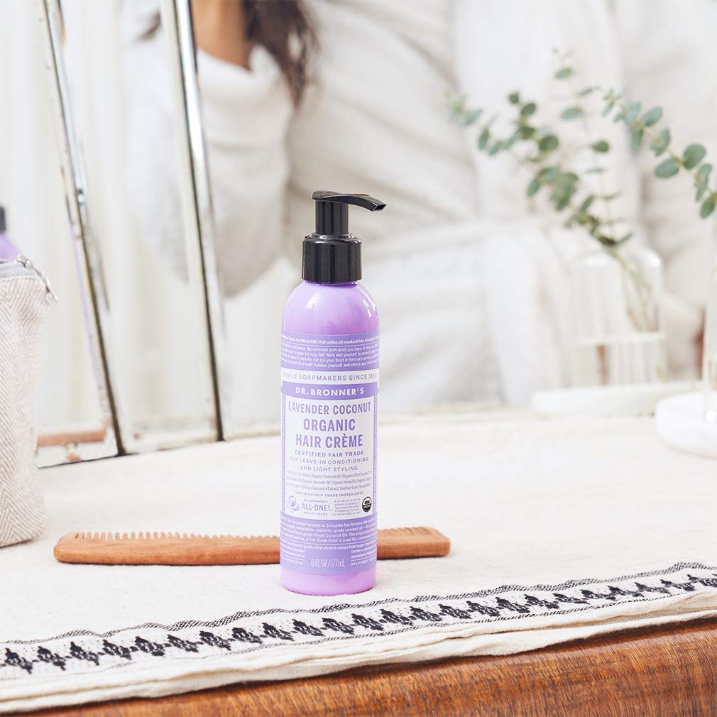 Hands applying Dr. Bronner's Hair Creme for light hold and silky feel.