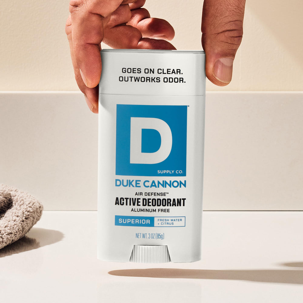 Active man applying Air Defense deodorant before a workout.