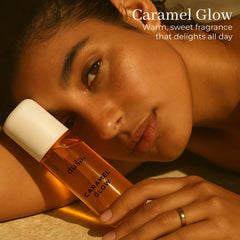 DUSA Caramel Glow spray pump delivering a light, refreshing mist for hair and skin.