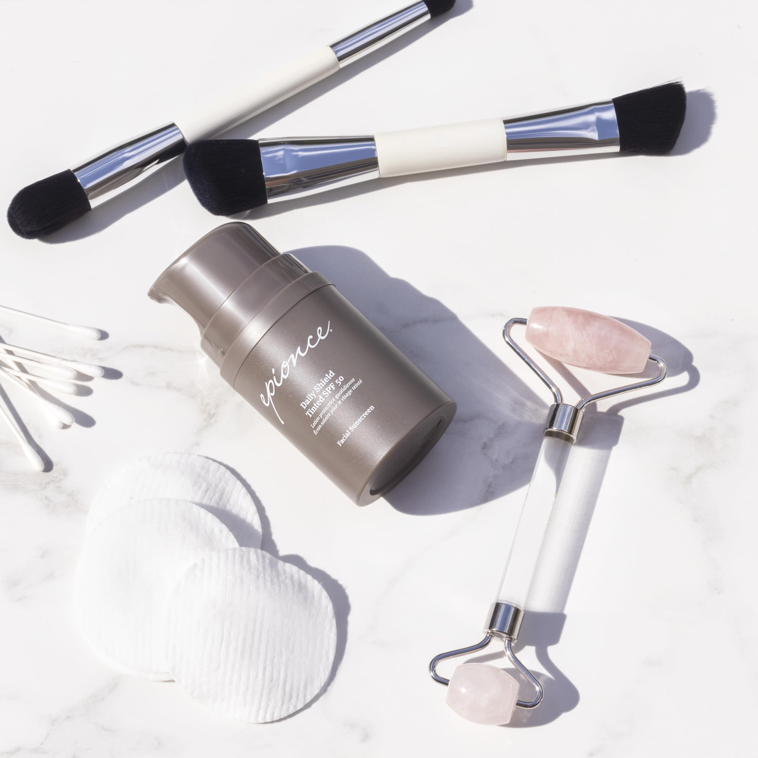 Epionce Daily Shield bottle beside makeup bag for under-makeup wear