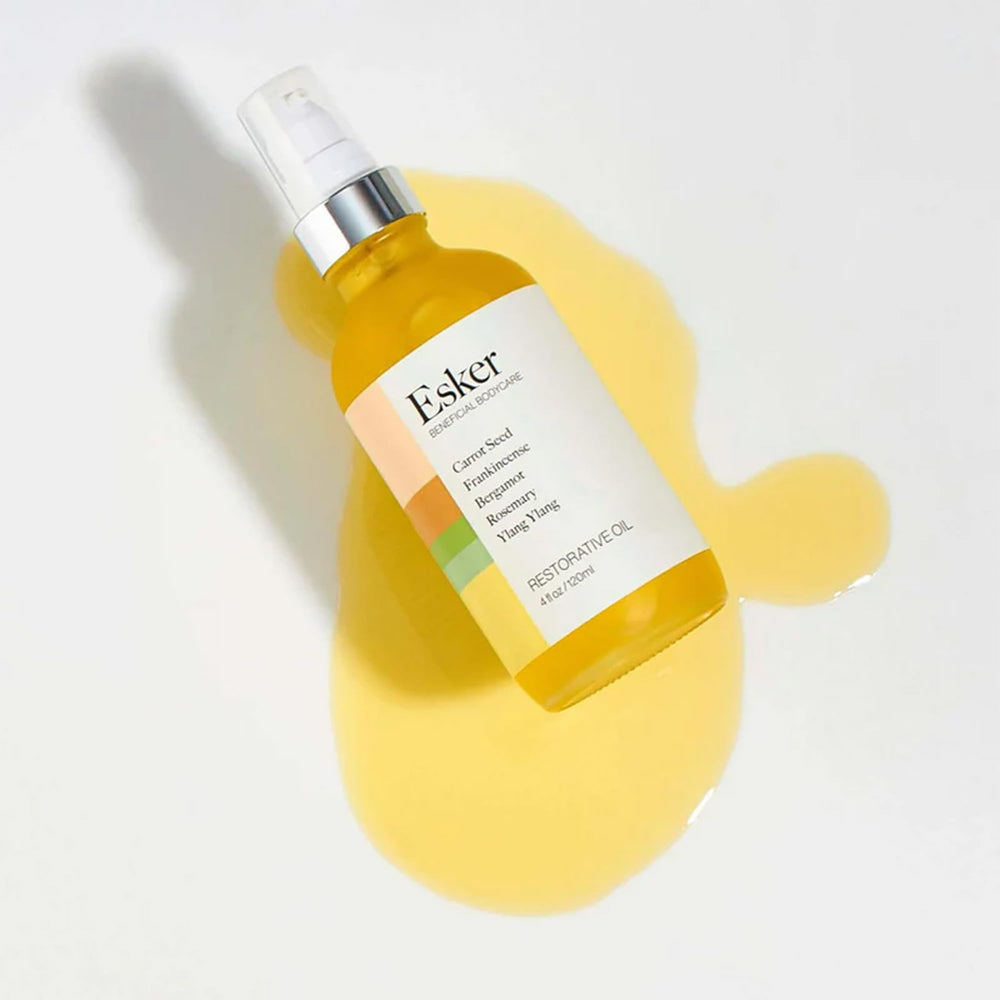 ESKER Restorative Body Oil bottle in hand during massage for circulation.