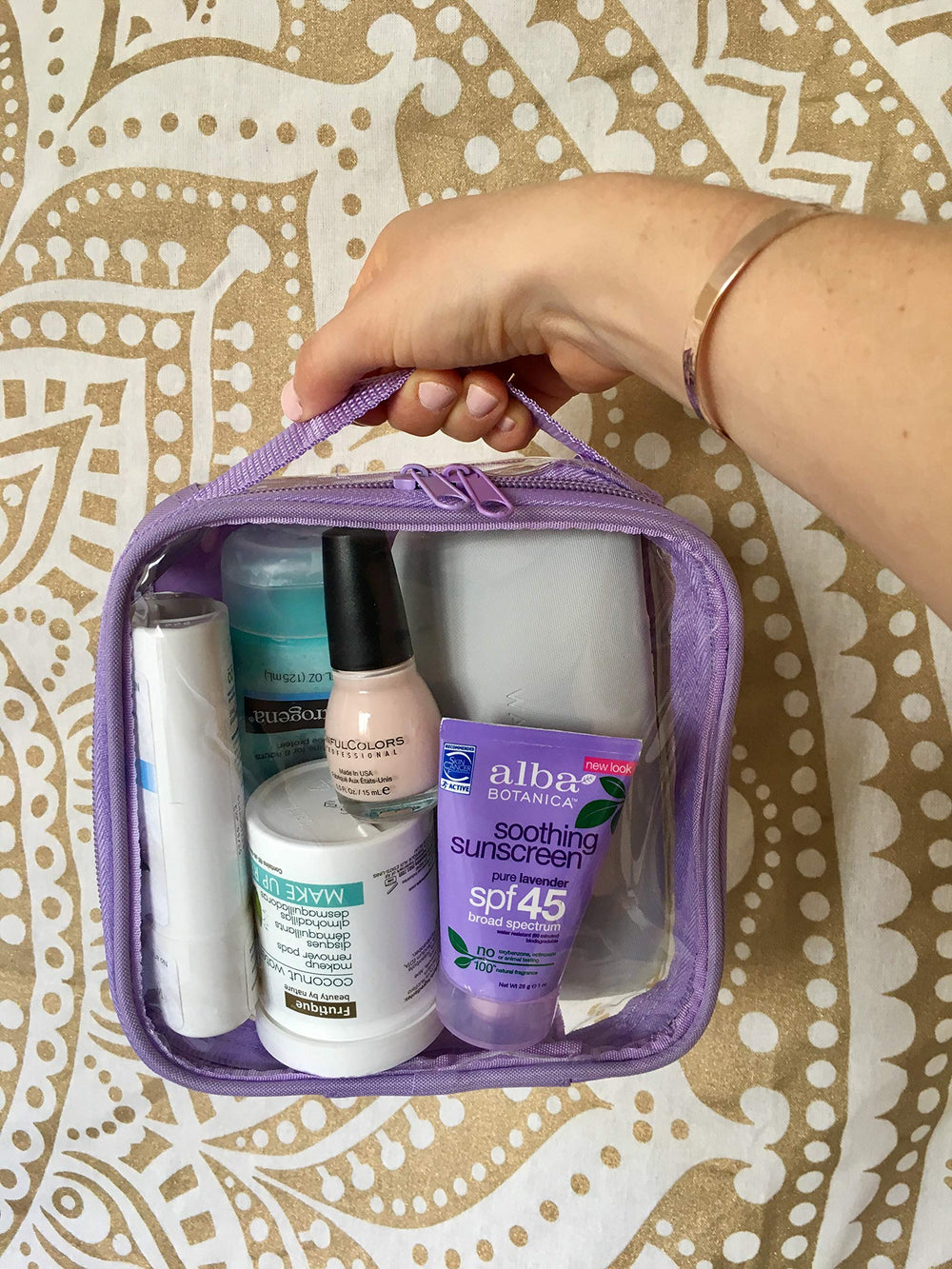 EzPacking clear toiletry bag lilac on travel desk ready for organization.