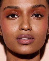 Fenty Glow lip color swatch on lips with long-lasting shine and moisture.