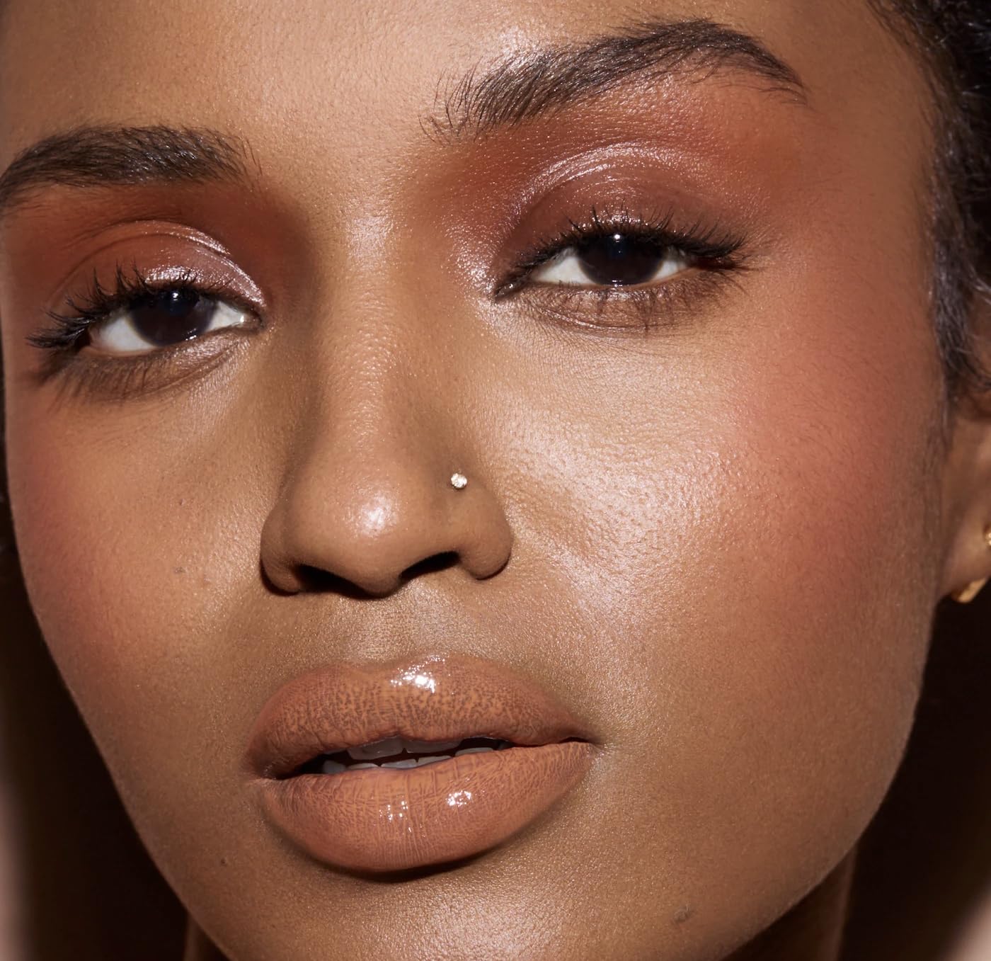 FENTY BEAUTY Gloss Bomb Cream Color Drip Honey Waffles glossy finish on lips.