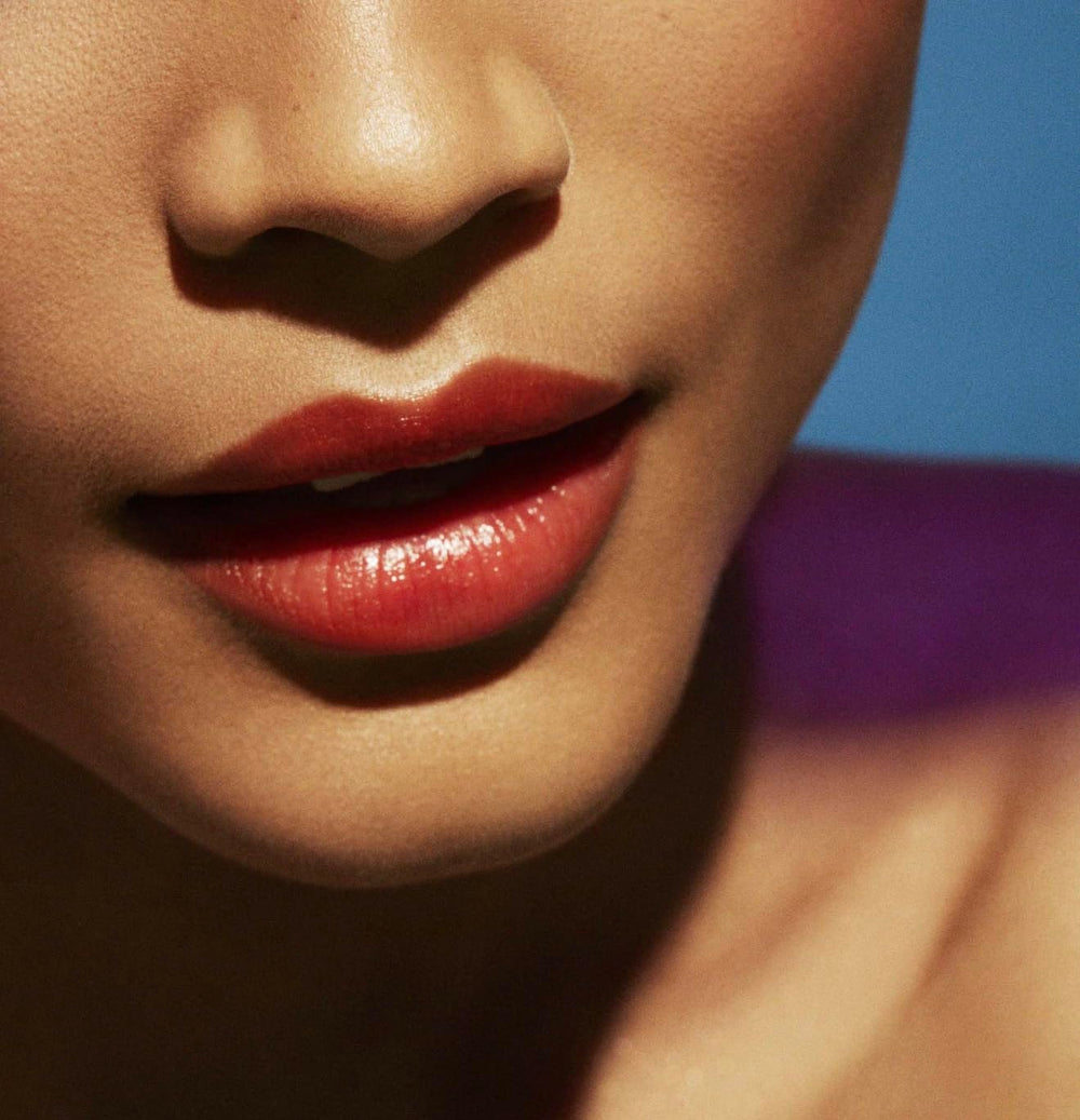 Fenty Beauty Poutsicle Zesty Bestie lip application close-up highlights smooth glossy finish