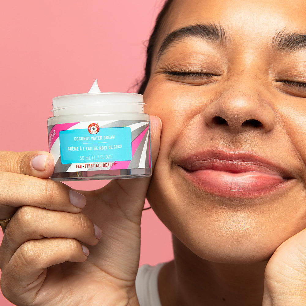 First Aid Beauty Coconut Water Cream being applied on clean skin for smoothness.