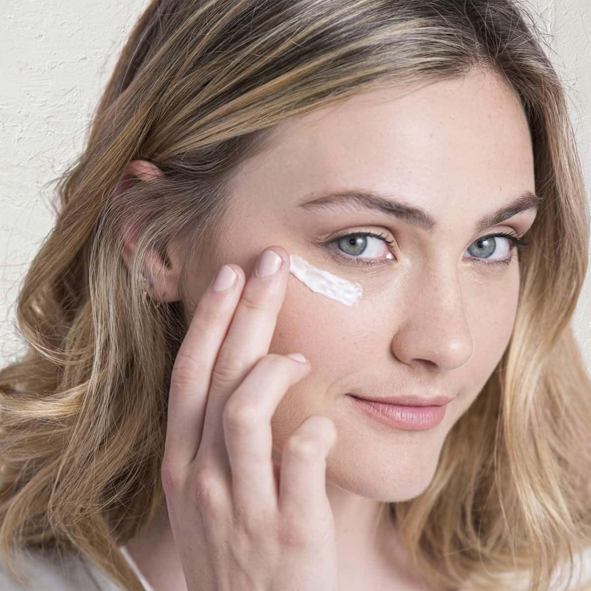 Fleur & Bee eye cream application shows easy daily dab for refreshed eyes.