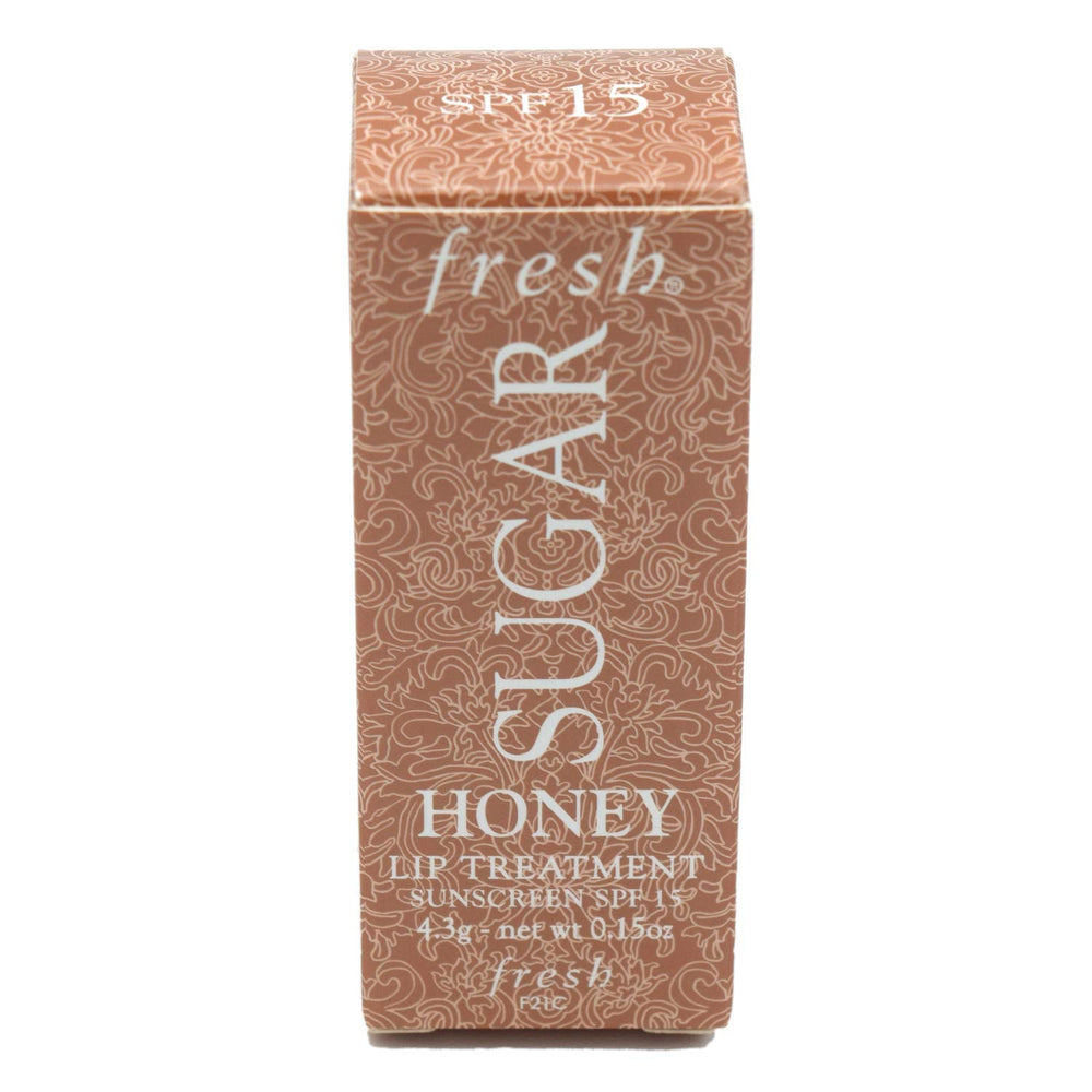 Fresh Sugar Honey Tinted Lip Treatment bottle in sunlight highlights SPF 15 protection.