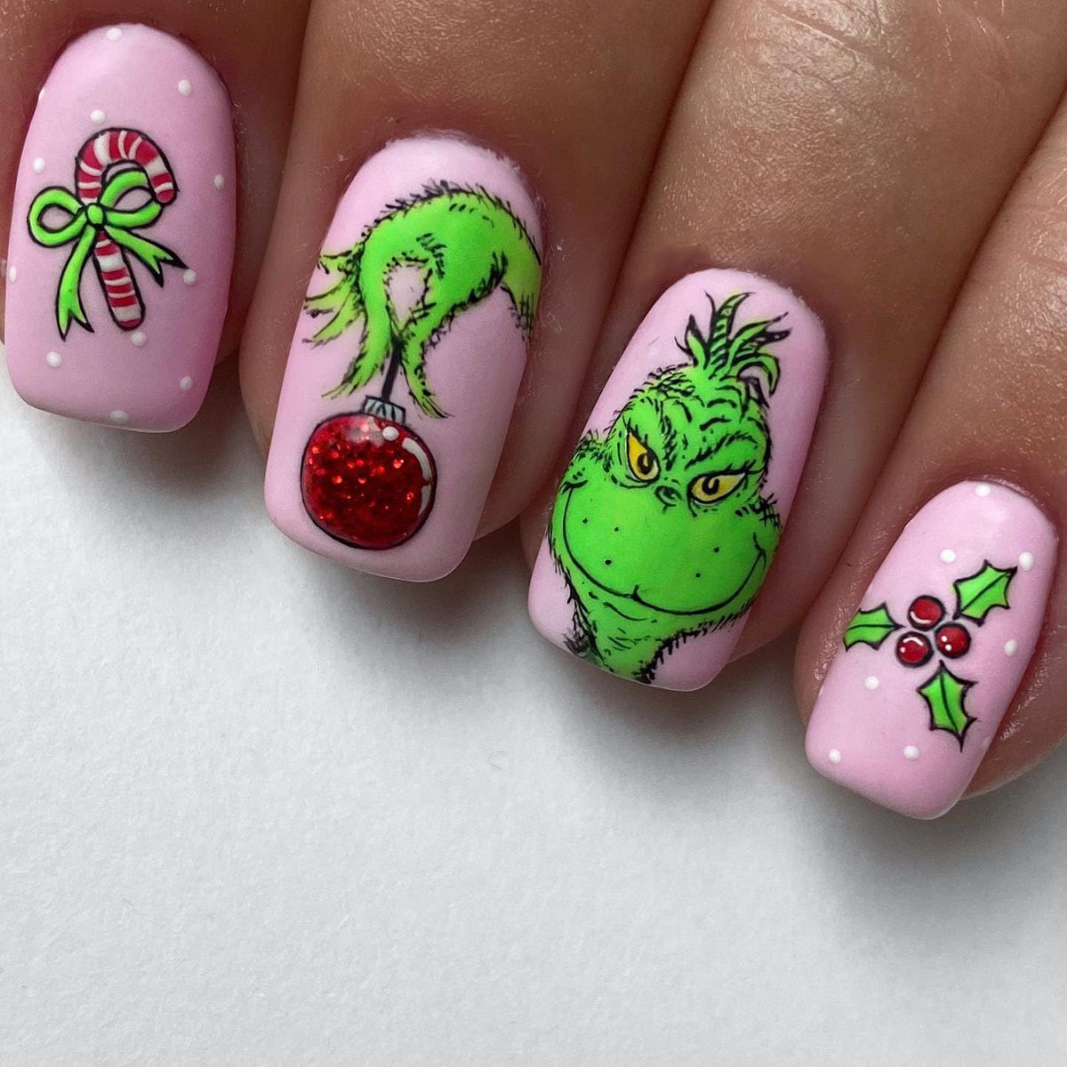 FUKIDOG Christmas nails in pink square with green-haired monster for festive flair.