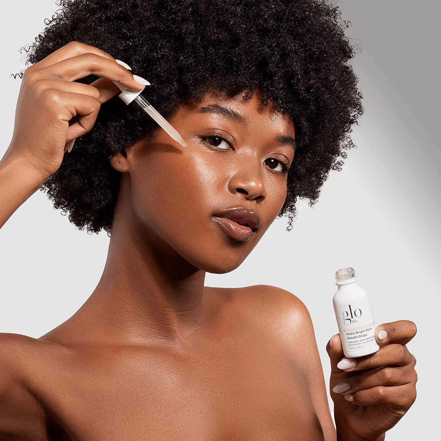 Glo Skin Beauty Alpha Arbutin Drops applied to hand for even tone.