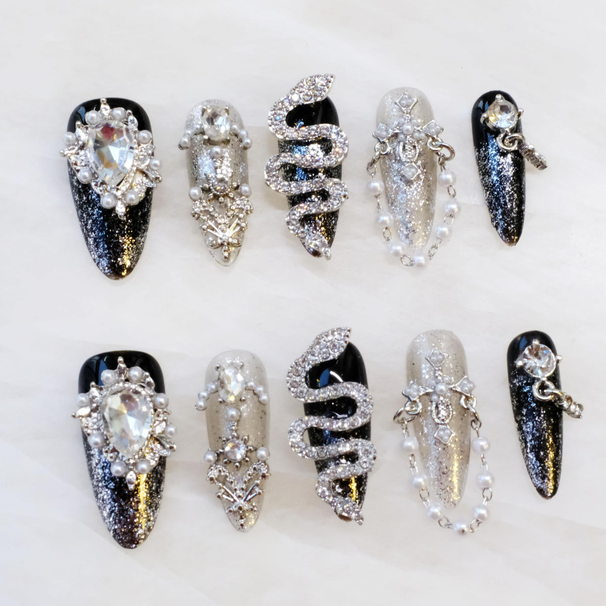 GLORS luxury long almond nails with serpent motif for dramatic evening glam.