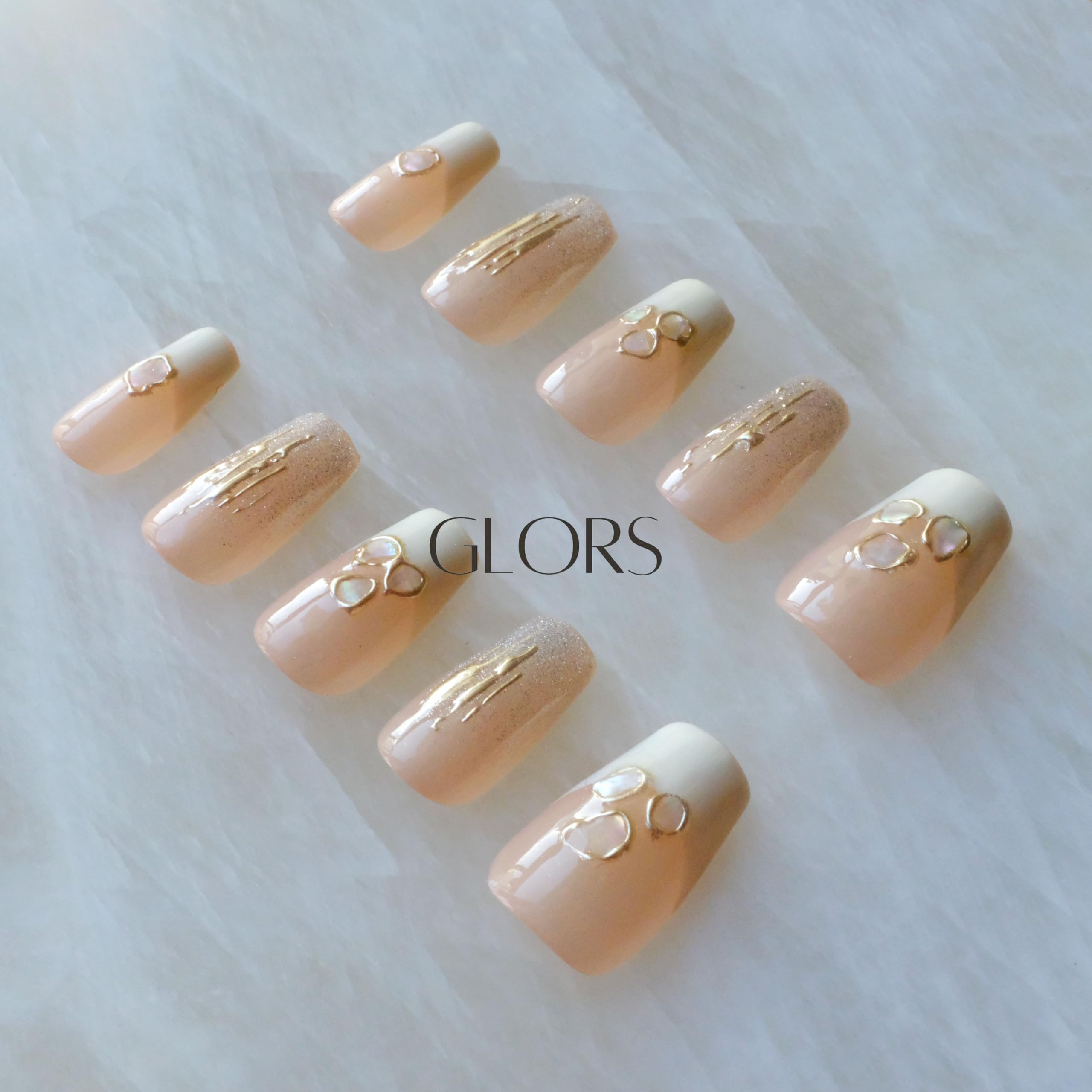 GLORS Purly nails with nude base and shimmering accents for elegant appeal.