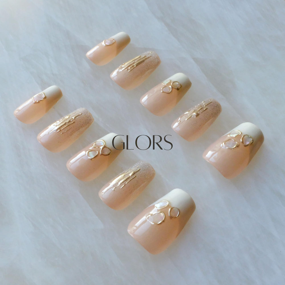 GLORS Purly nails with nude base and shimmering accents for elegant appeal.