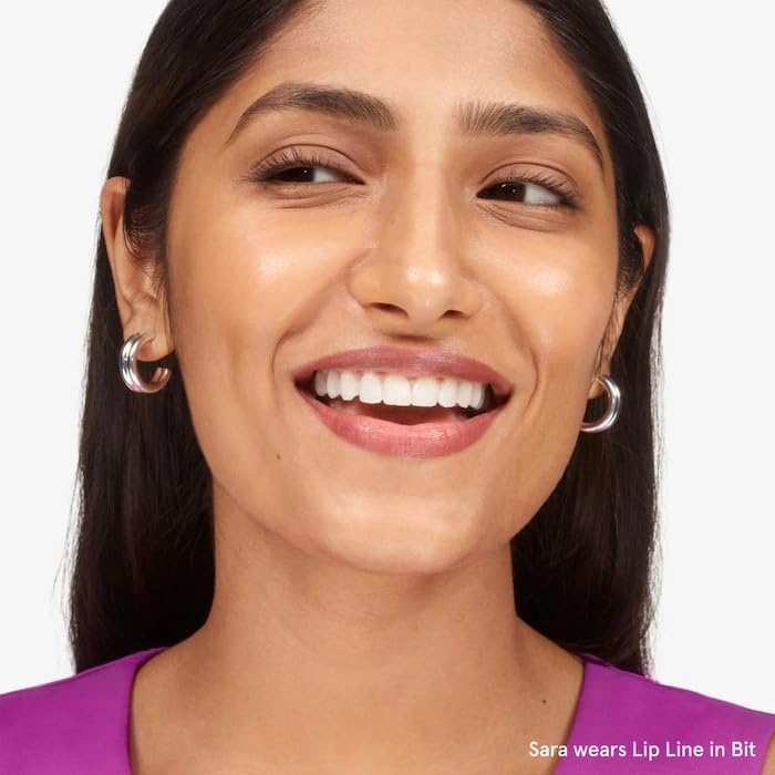 Glossier Bit Lip Liner product on table with other cosmetics.