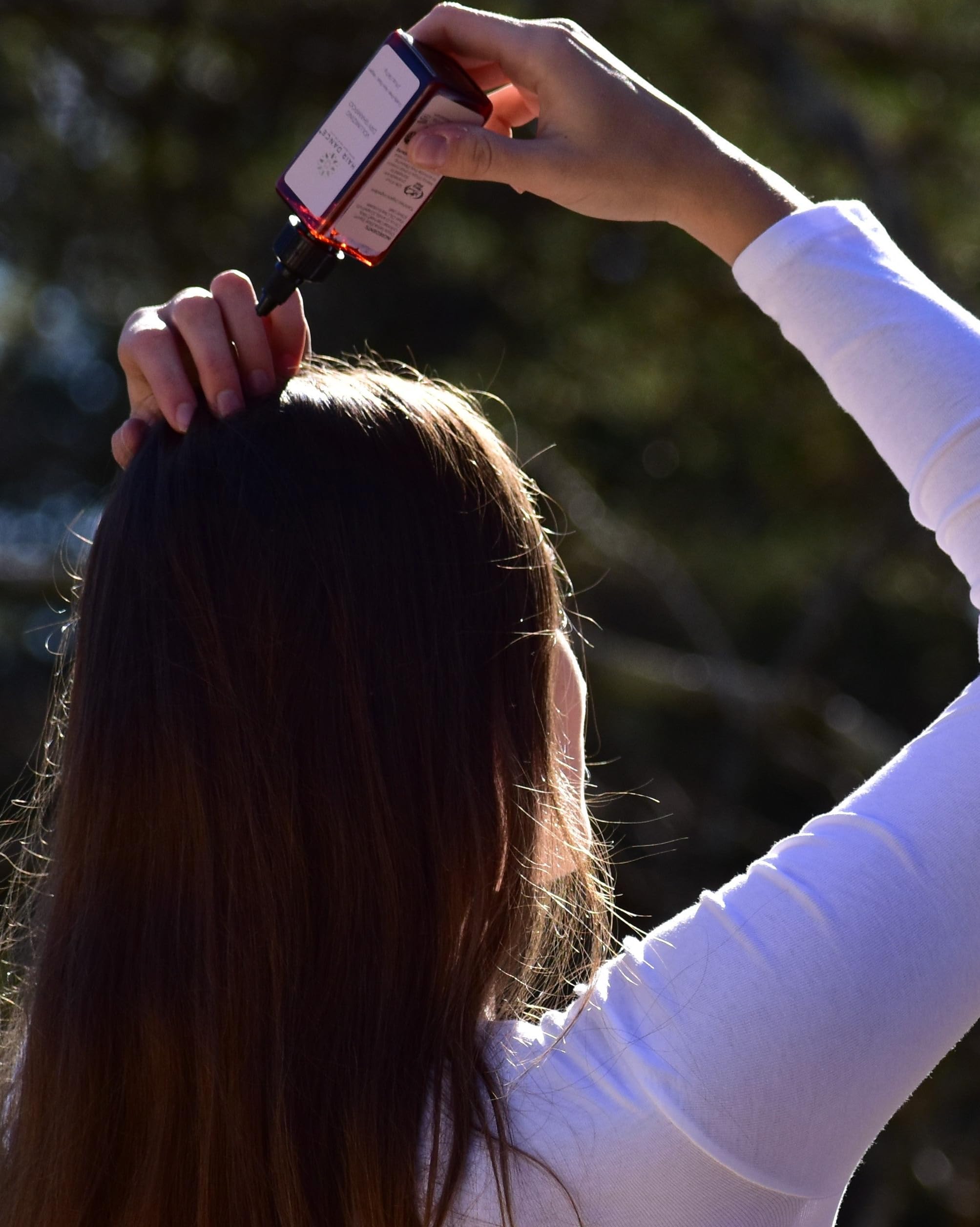 Hair Dance travel-sized bottle in a purse for travel touch-ups