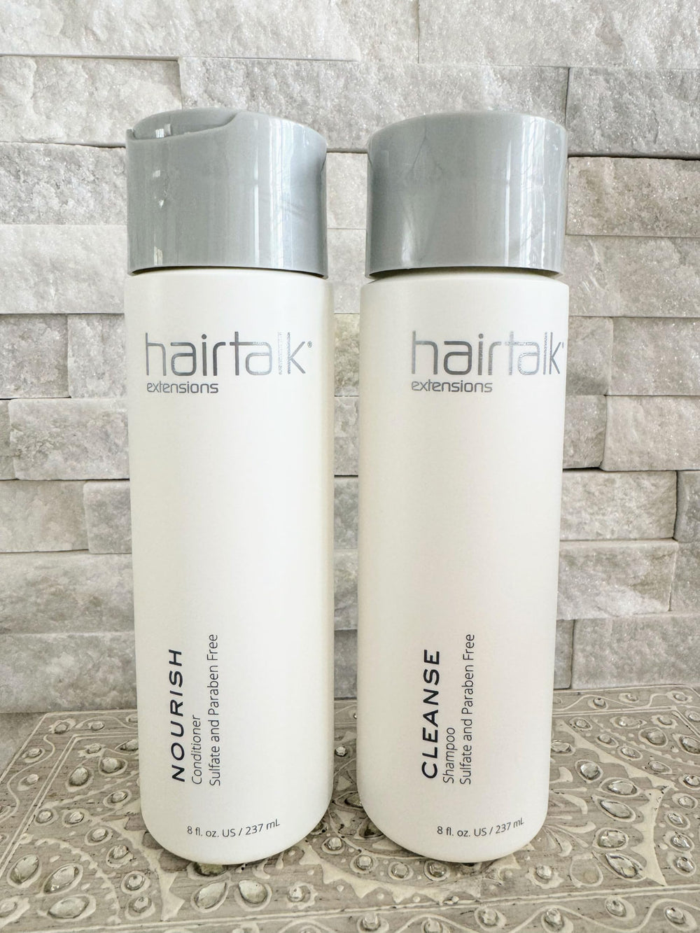 Hairtalk Extensions Cleanse Shampoo bottle highlights gentle cleansing for extensions and reduced buildup.