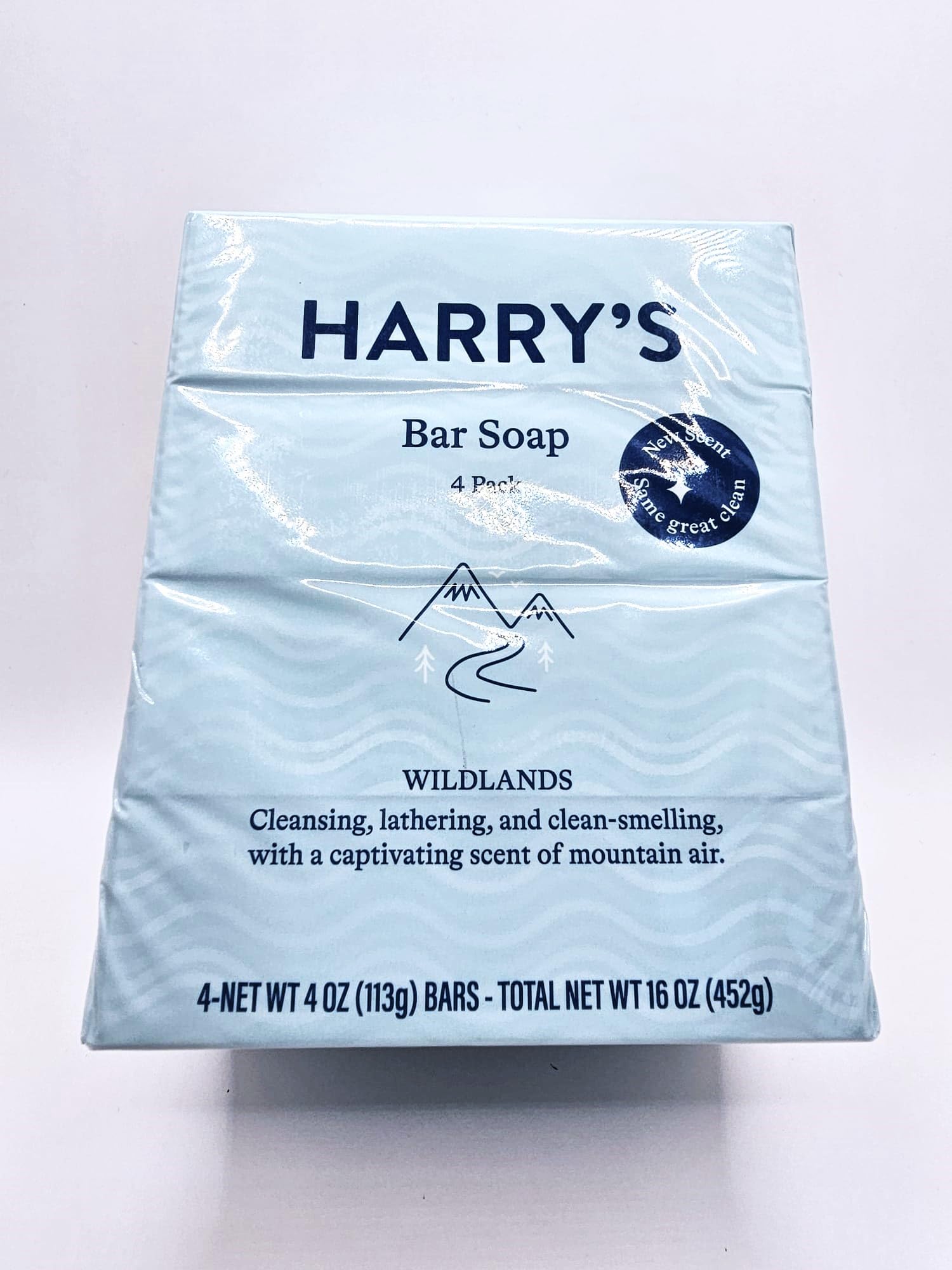 Harry's Wildlands blue bars resting on wood for rugged outdoor cleansing.